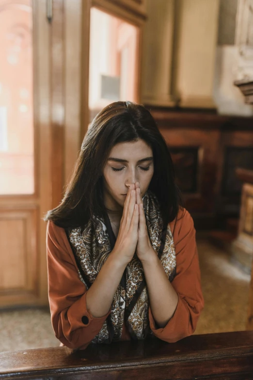 a woman who is sitting at a table, covering her mouth