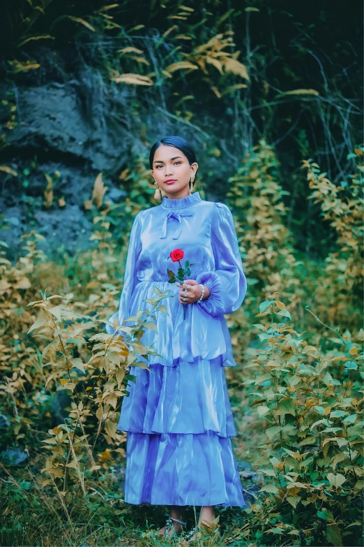 woman standing in a field holding a bouquet of flowers