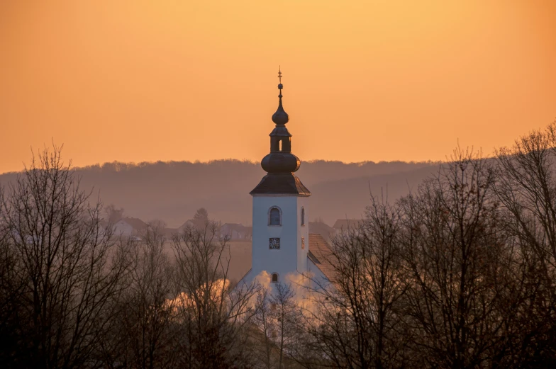 a large church steeple with a light colored sky