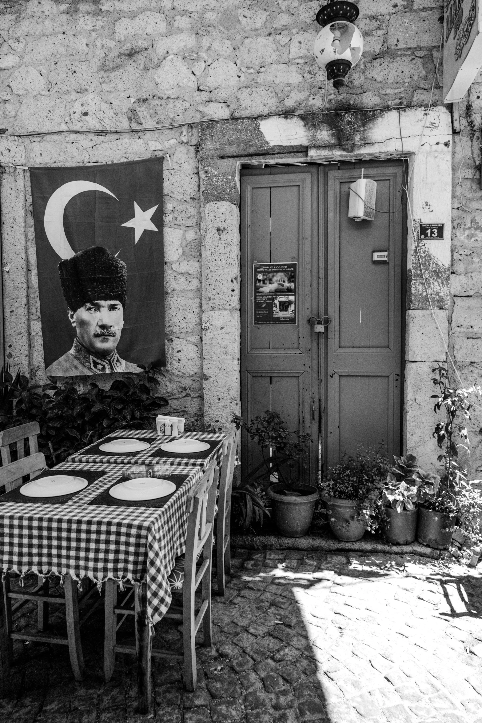 a table sitting outside with a painting on the wall behind it