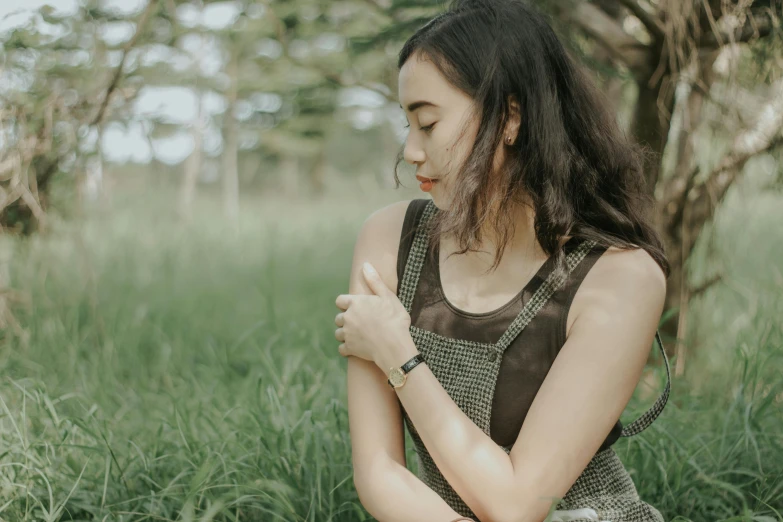 a beautiful woman standing in the middle of grass