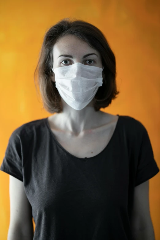 a woman with a face mask on is looking at the camera