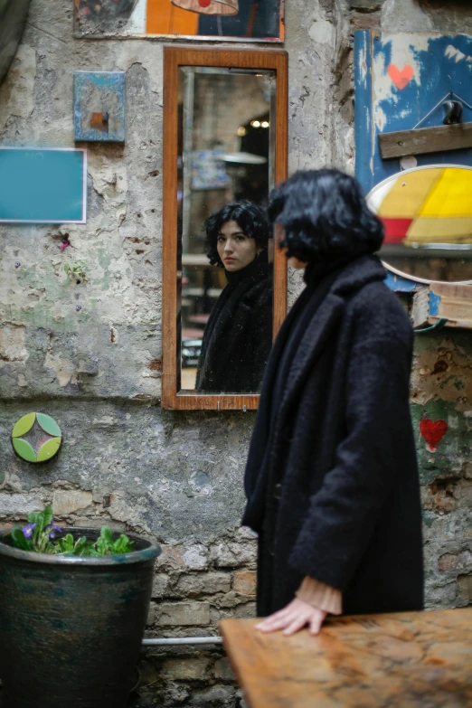 a woman staring at her reflection in a mirror