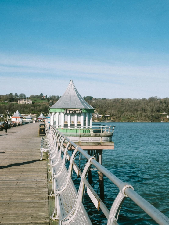a pier that has a wooden and metal fence next to the water