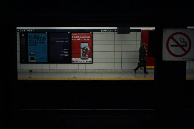 a lone person walking down a subway platform