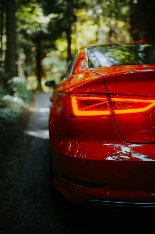 the rear end of a red car on a road