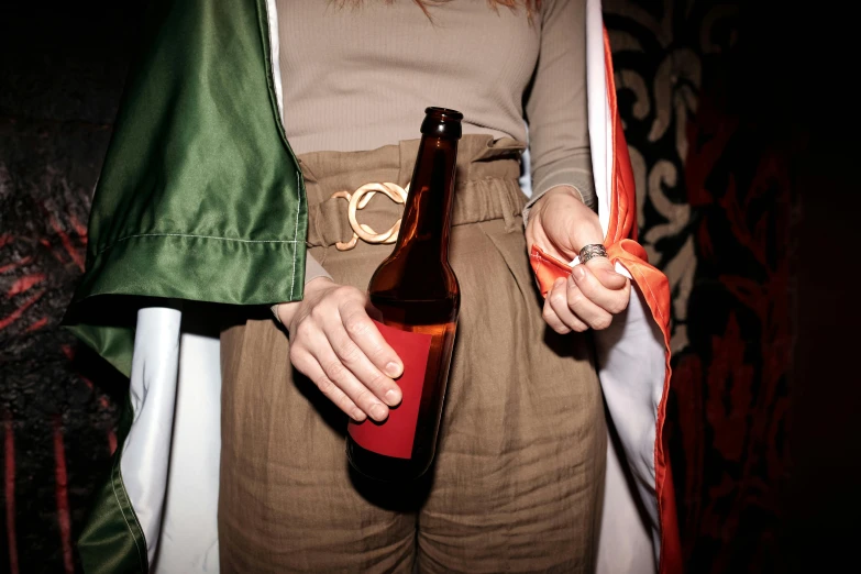 a person holding a beer and jacket in their hands