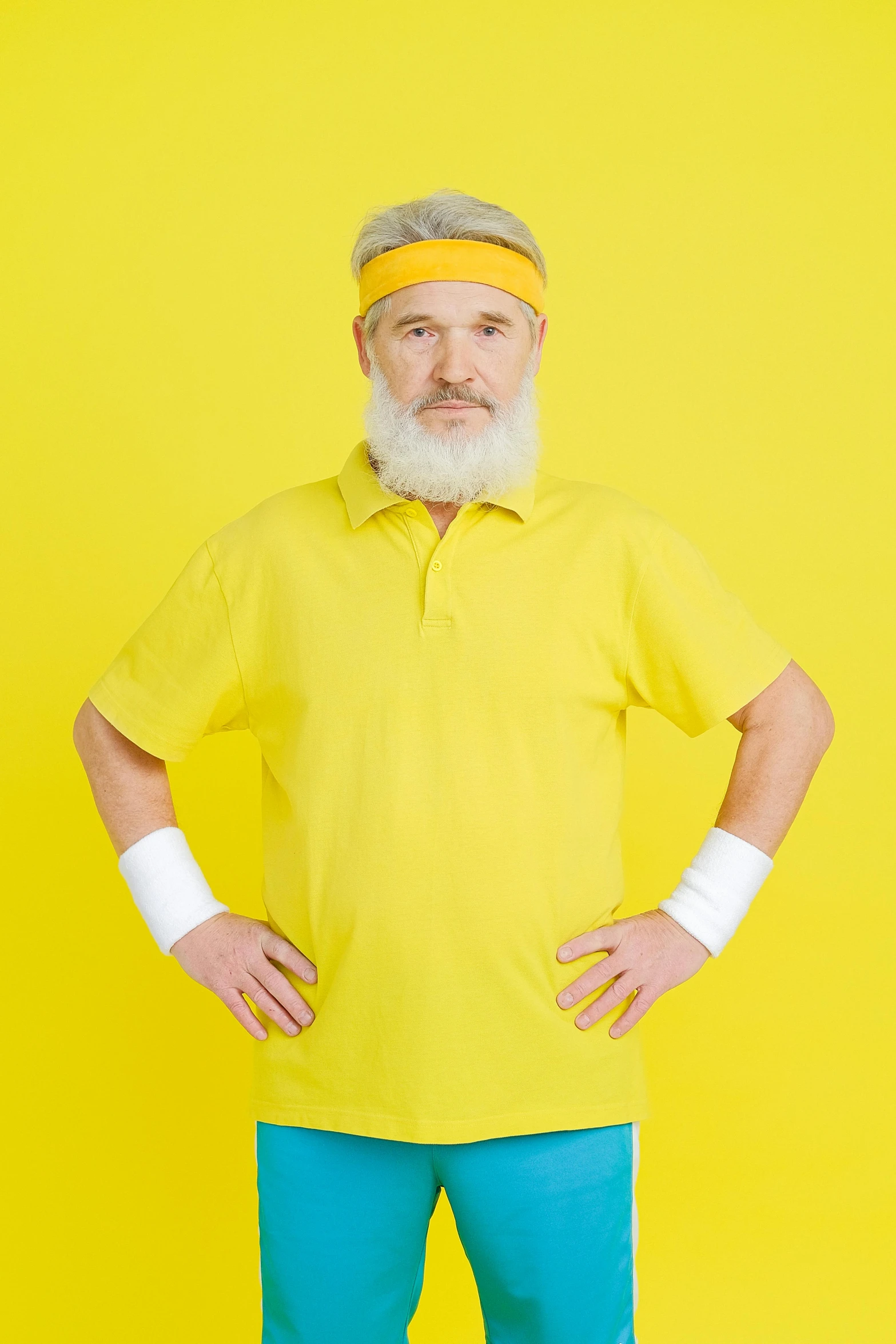 a man with a headband and eye patch standing in front of a yellow background