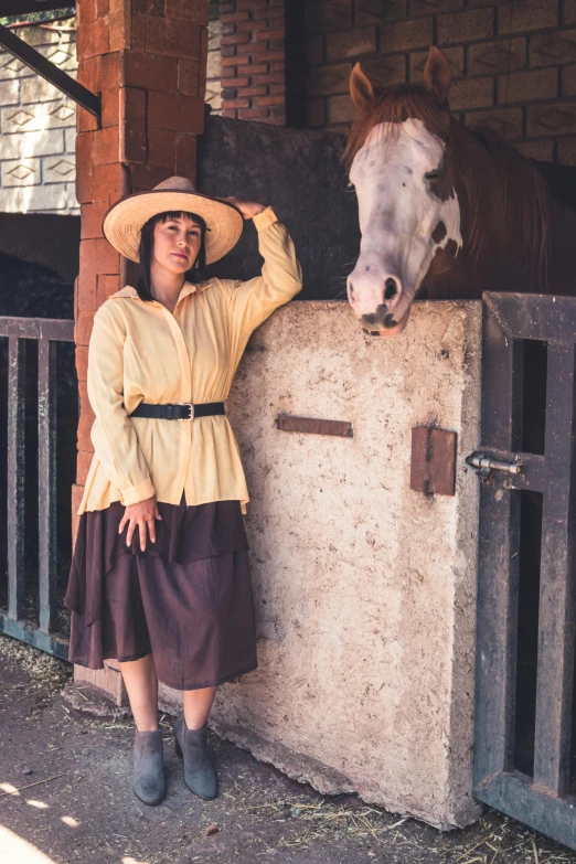 woman standing next to a fence in front of horse