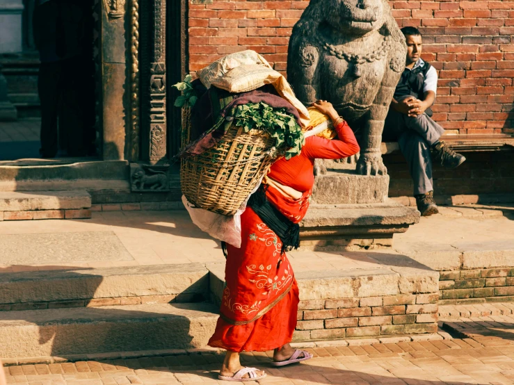 a woman carrying soing by her back walking down stairs