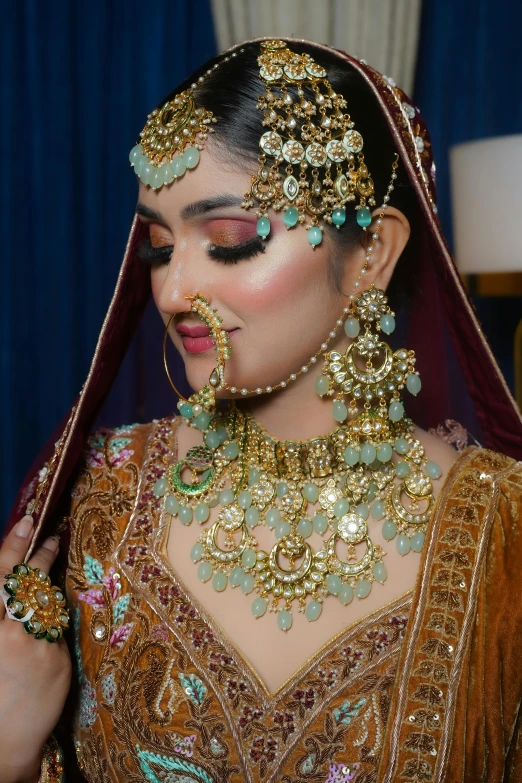 a woman wearing elaborate jewelry in gold and green