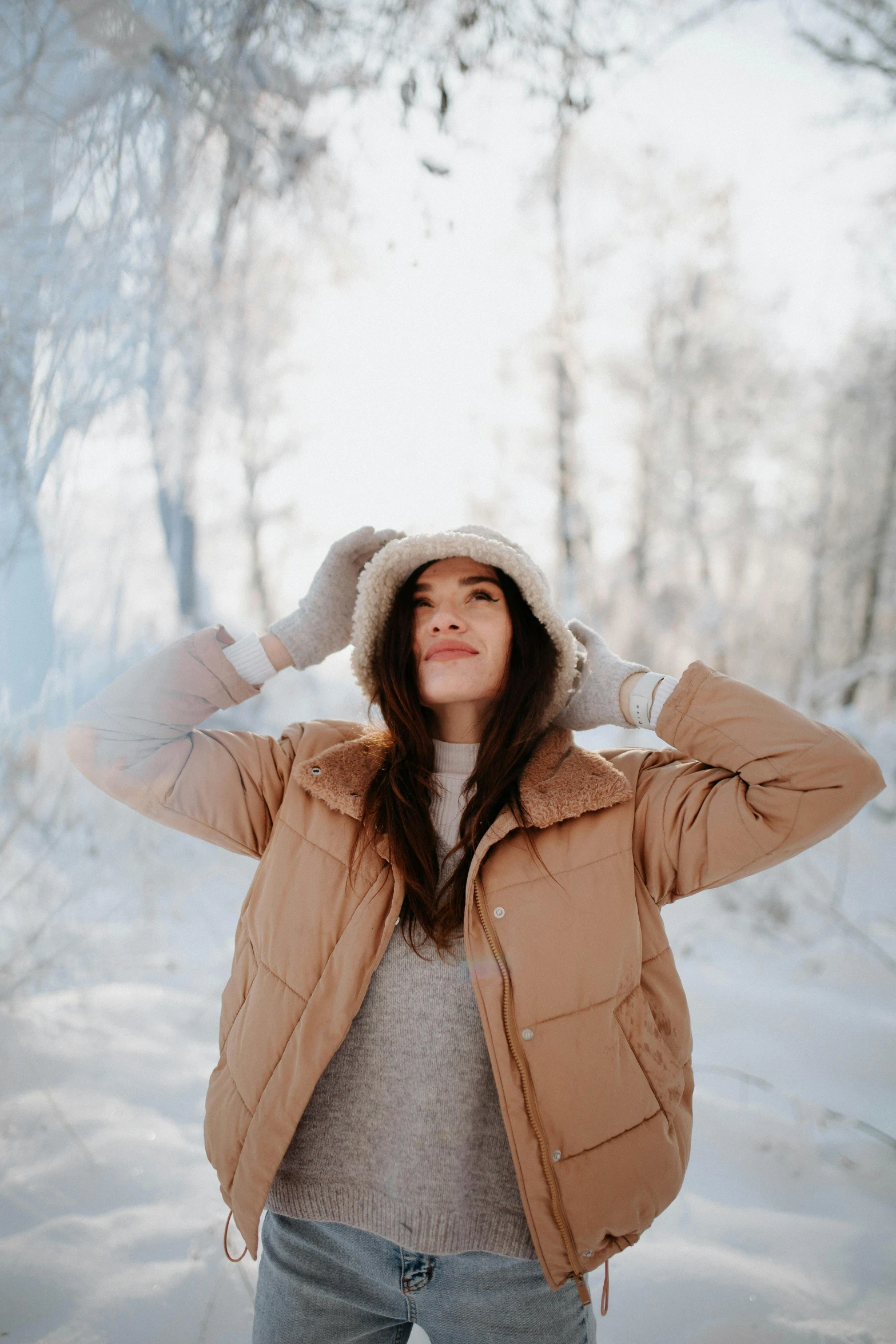 the woman is wearing a jacket and a hat in the snow