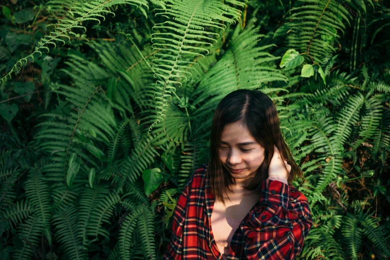 girl standing among the plants posing for a po