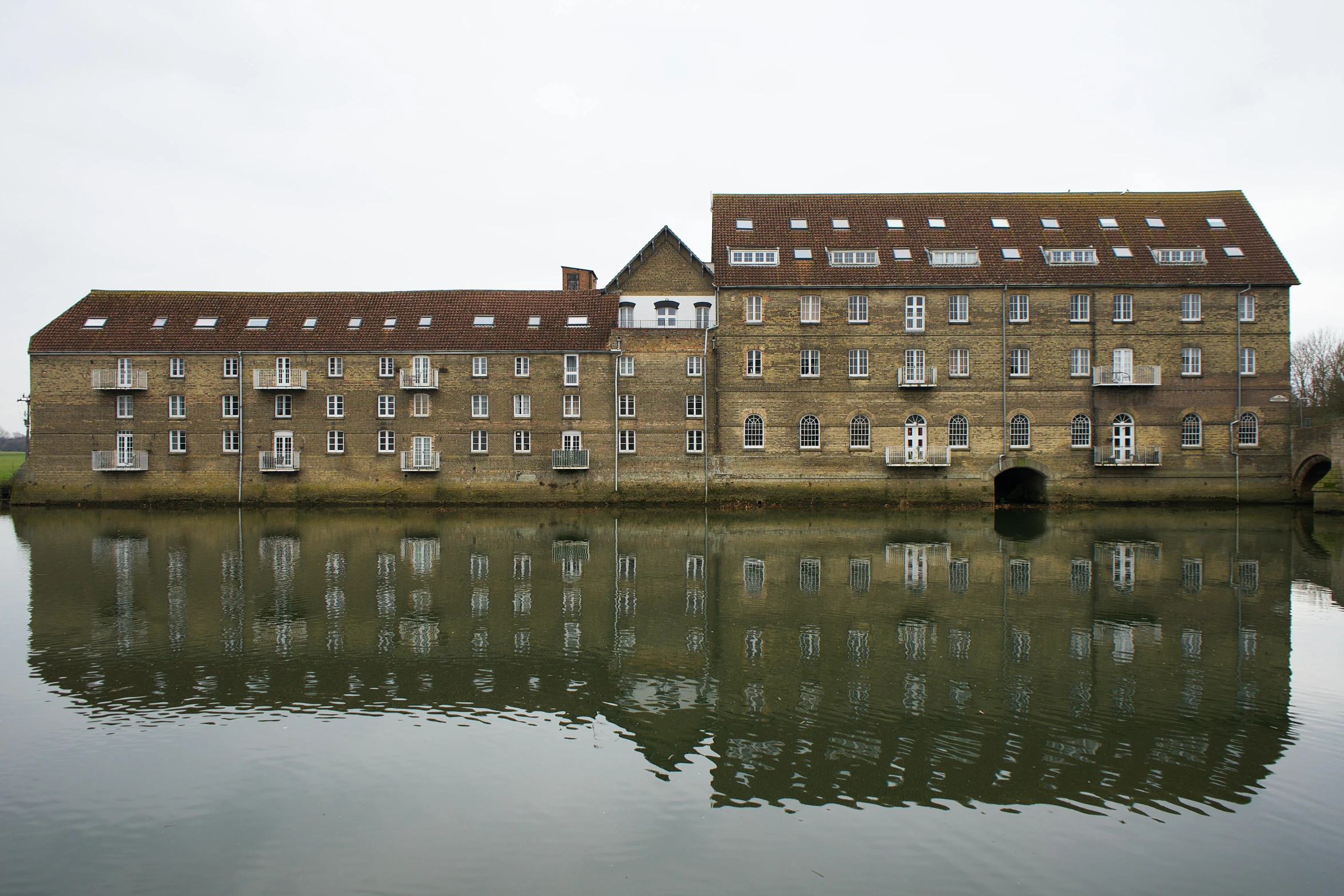 a large brick building that is reflecting in the water