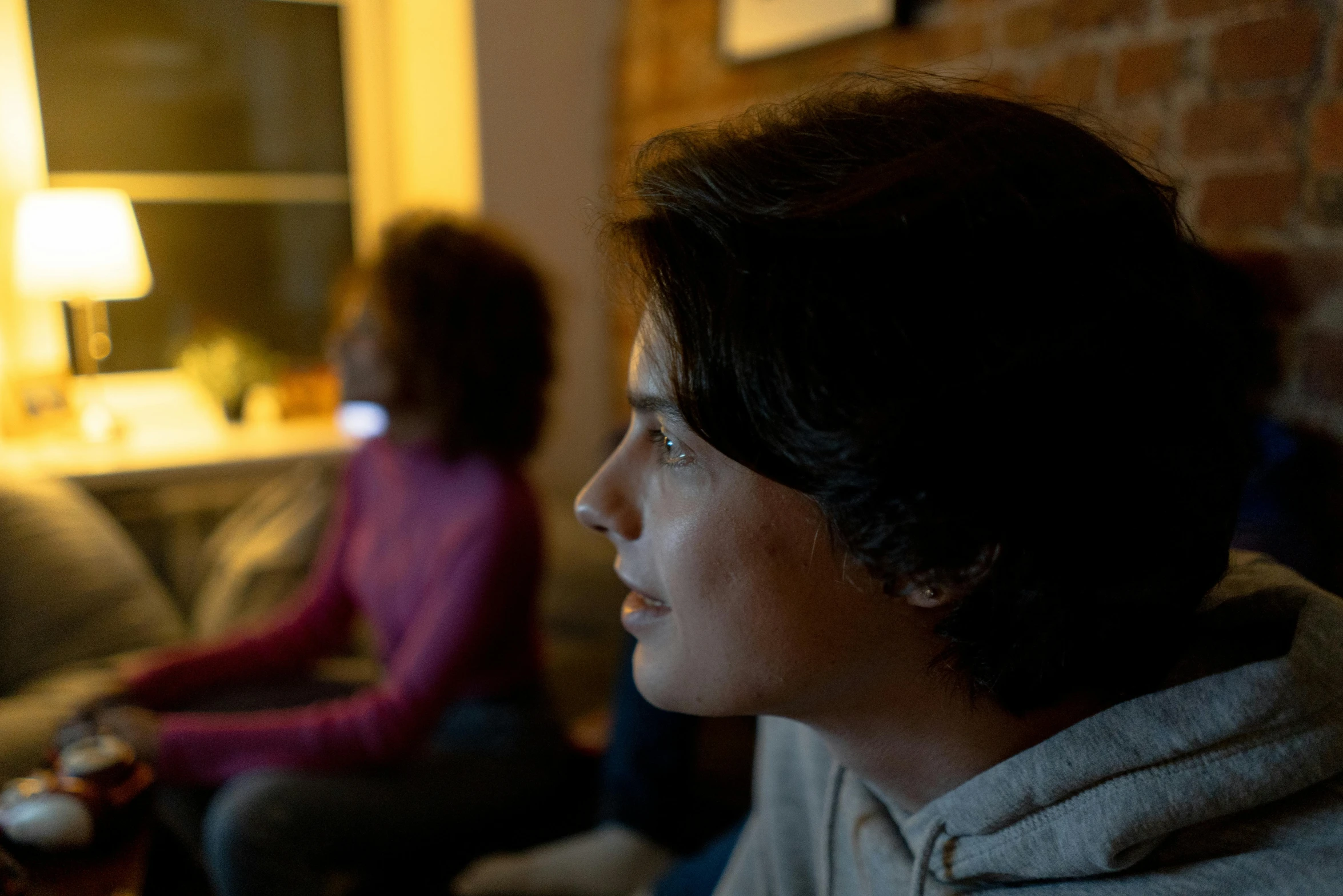 a woman is sitting on the couch looking at the television