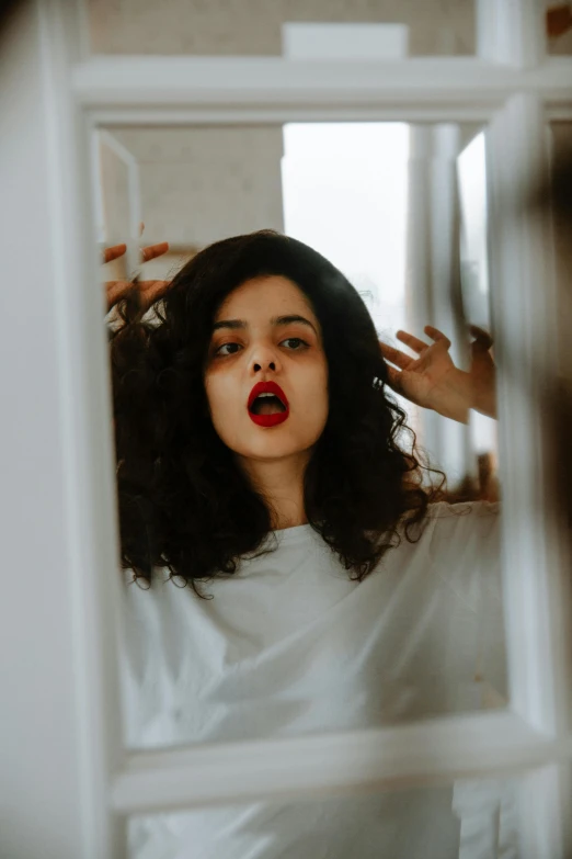 a person standing in front of a mirror making weird faces