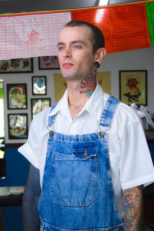 the man with many tattoos wearing an overalls