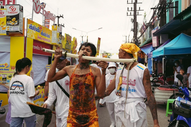 people wearing colorful clothing walk down a city street