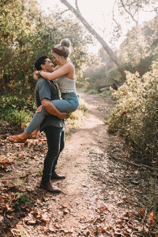 a woman carrying her boyfriend while walking through the woods