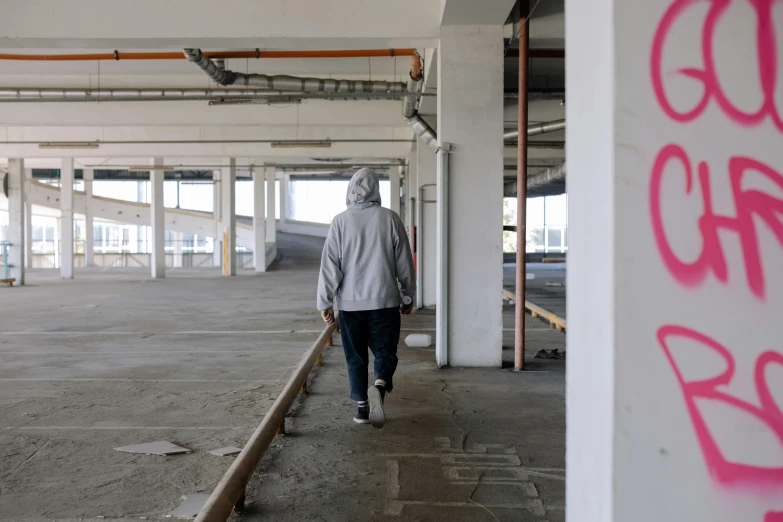 a person walking inside of a building next to large garages