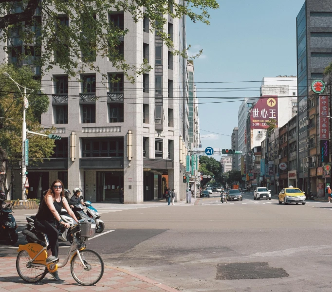 a woman riding her bicycle down the street