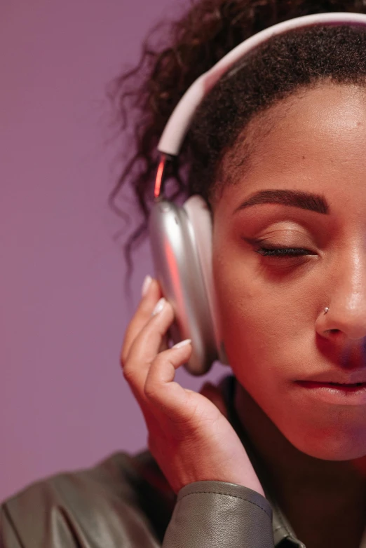 a woman in grey shirt and headphones next to wall