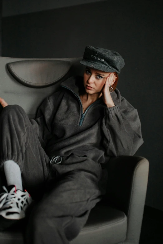 a woman in a hat sitting on top of a chair