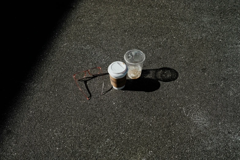 two empty paper cups are placed on the ground