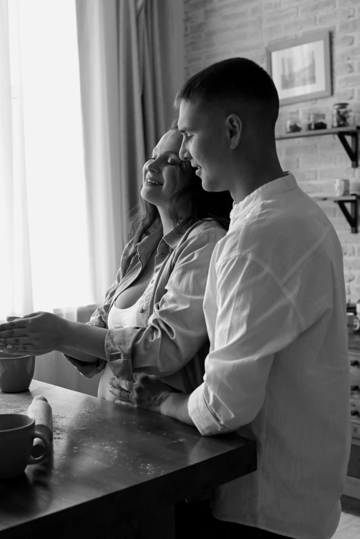 a man and woman looking at soing in a kitchen