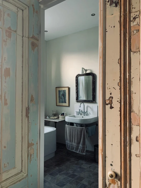 a white sink sitting in a bathroom under a mirror