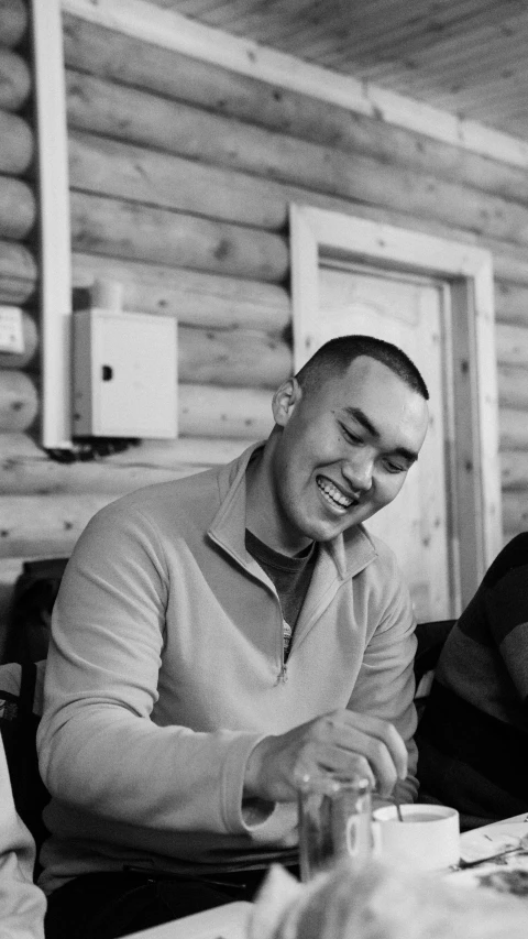 a man and a woman smile as they sit at a table