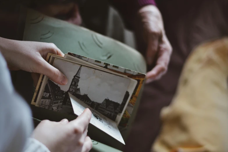 two women holding up an old pograph of a dog