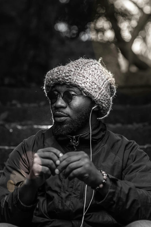 a man is sitting down using his cell phone