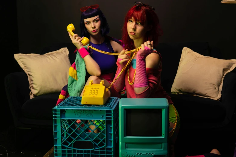 two women in drag up clothes talking on the phone