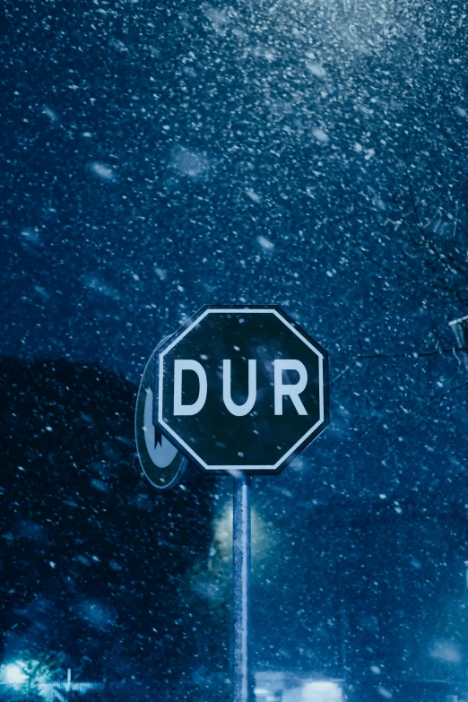 a street sign sitting under snow on the side of a road