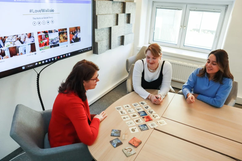 some girls play a board game together in a board game room