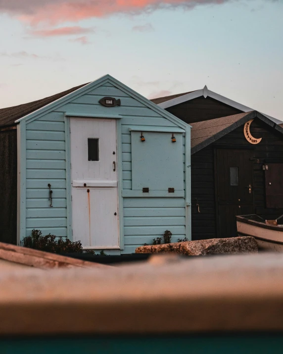 a blue house with a white door and windows is next to other houses