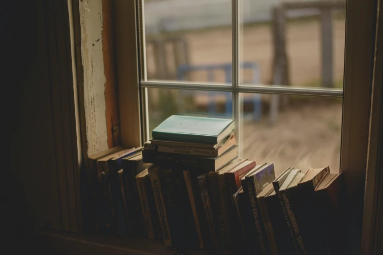 a bookshelf full of books with the window opened