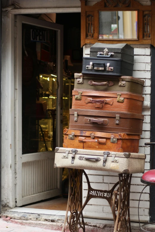 a stack of suit cases sitting on top of a wooden table