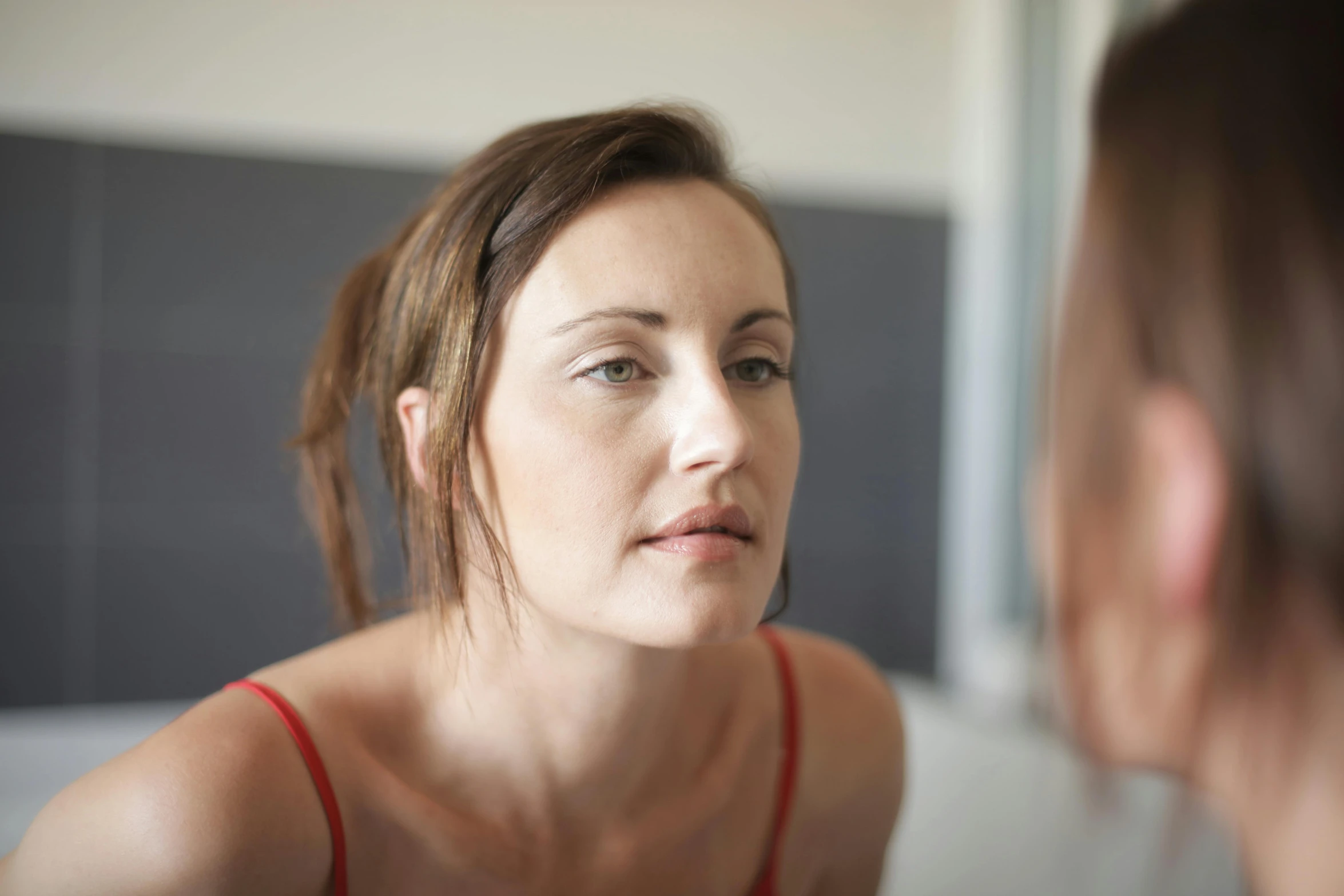 a woman with very long hair looking into her mirror