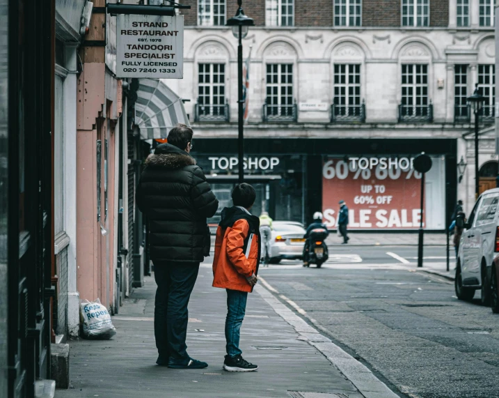 two people standing on the side of the road