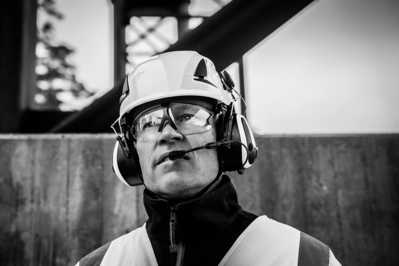 a man wearing a helmet and standing near a wall