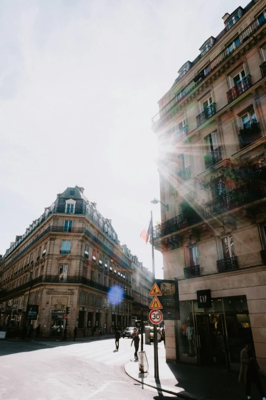 the street has tall buildings and many people walking on it