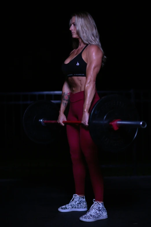 a woman holding a barbell in her right hand