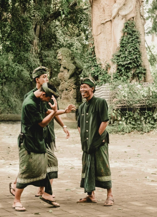 two men standing and one wearing a hat