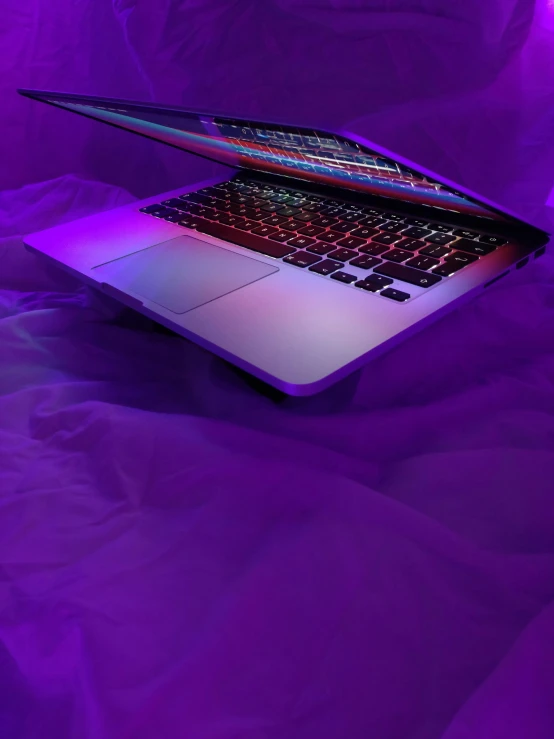 a laptop computer is lit up and purple