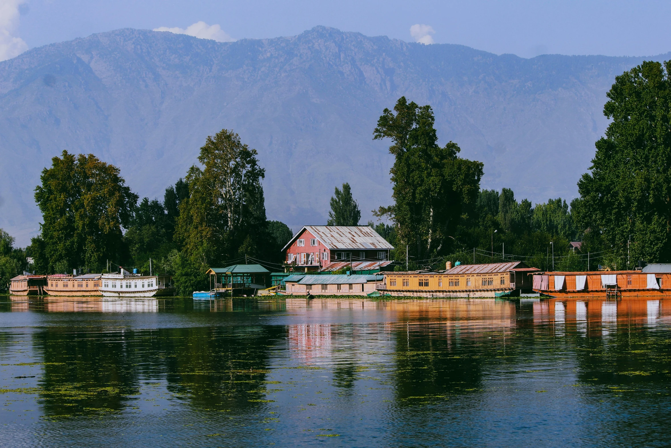 wooden boats sit in the water next to a mountain