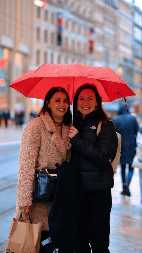 two people that are standing under an umbrella