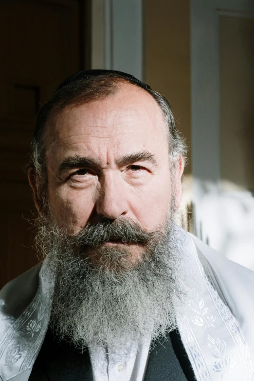 a man with a long beard and wearing a white shirt