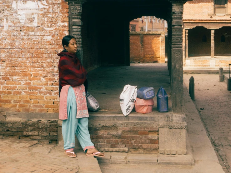 a woman standing on the steps with bags in front of her